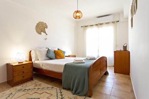 a bedroom with a bed and a dresser and a window at Cabanas Vintage Apartment in Tavira