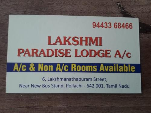 a sign on the side of a building at Lakshmi Paradise Lodge A/C in Pollāchi