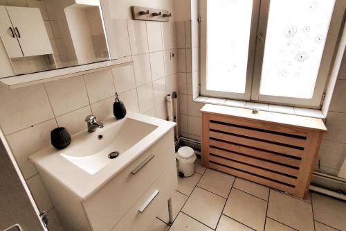 une salle de bain blanche avec un lavabo et une fenêtre dans l'établissement Logement entier proche tribunaux, à Douai