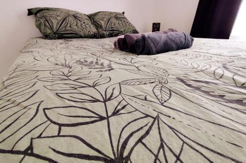 - un lit avec une couverture design dans l'établissement Logement entier proche tribunaux, à Douai