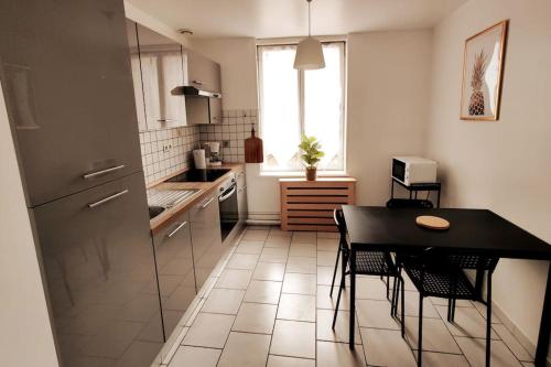 une cuisine avec une table noire et des chaises dans l'établissement Logement entier proche tribunaux, à Douai
