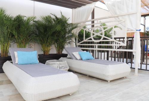 two white wicker chairs and tables on a balcony at Matisia Hotel Boutique in Guaduas