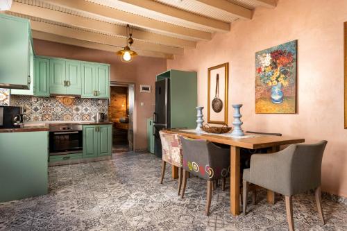 a kitchen with green cabinets and a wooden table at Aspasia's House in Zákros