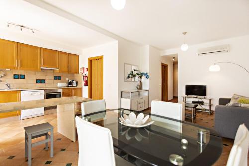a kitchen and living room with a table and chairs at Camélia Apartment in Santa Luzia