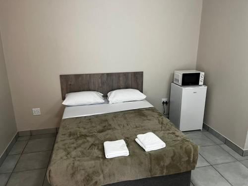 um quarto com uma cama com duas toalhas em Ecomotel Louis Botha em Joanesburgo