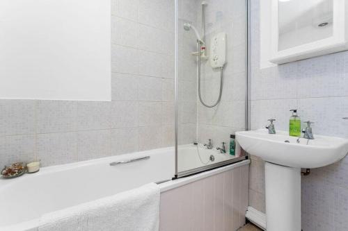 y baño blanco con lavabo y ducha. en Edinburgh perfect location en Edimburgo