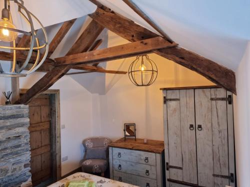 a bedroom with a bed and a desk and a chandelier at The Old Pottery 2 Person Dog Friendly Cottage in Delabole