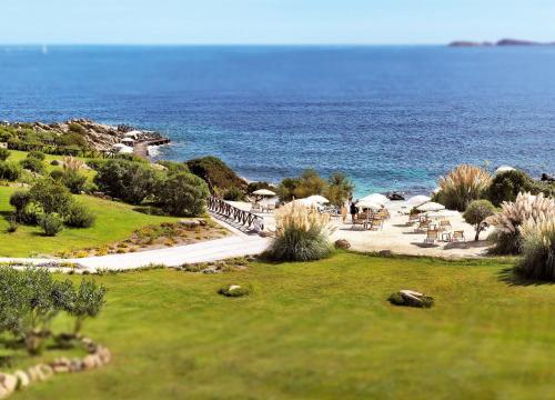 a view of a beach with the ocean in the background at COLONNA RESORT, a Colonna Luxury Beach Hotel, Porto Cervo in Porto Cervo