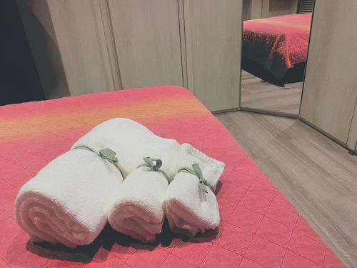 a pair of towels on a bed in front of a mirror at FRESH HOME in Turin