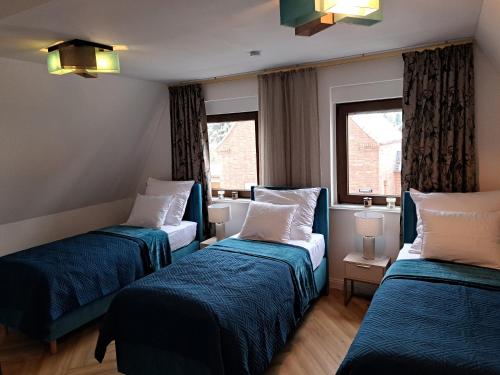 a hotel room with two beds and two windows at Elsdorf Stay in Elsdorf