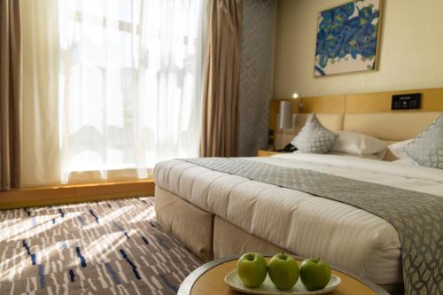 a hotel room with two beds and two apples on a table at Qasr Al Sahab Hotel Makkah in Makkah