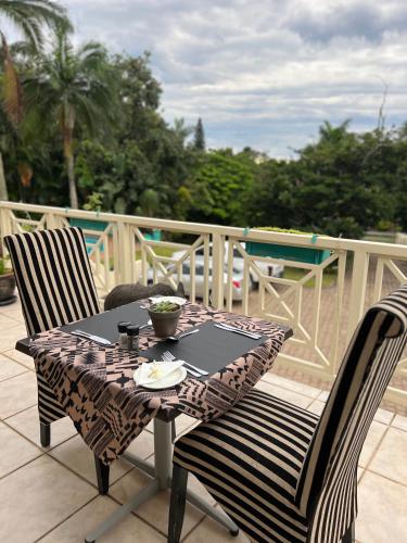 een tafel en twee stoelen op een terras bij Whalesong Guest House in St Lucia