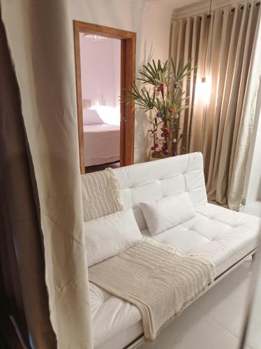um sofá branco numa sala de estar com um espelho em Flat Canto dos Pássaros em Itacaré