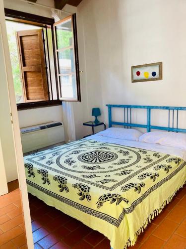 a bedroom with a bed with a blue and yellow blanket at Sea View Apartment in Capraia