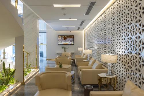 a waiting room at a hospital with chairs and tables at Qasr Al Sahab Hotel Makkah in Makkah