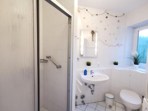 baño blanco con ducha y lavamanos en Strandrose, en Horumersiel