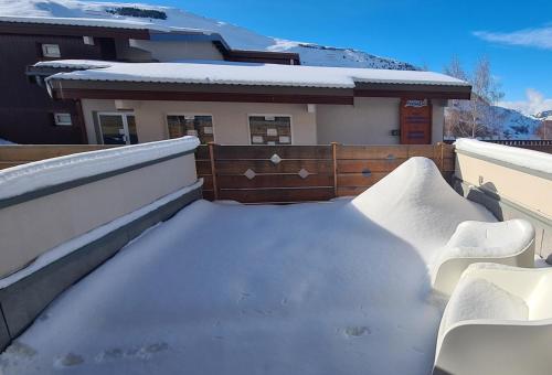 een berg sneeuw op een balkon van een huis bij Appartement avec terrasse in Les Deux Alpes