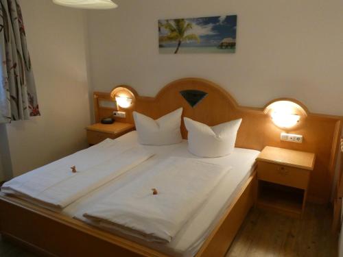 a bedroom with a large white bed with two lights at Ferienappartement Gutshof in Hohenwarth
