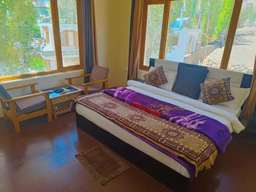 a bedroom with a large bed and a window at Hotel Malik Residency in Leh