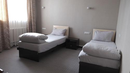 a hotel room with two beds and a window at Apple Hostel Bishkek in Bishkek