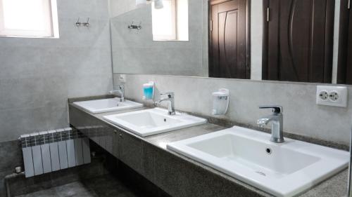 a bathroom with two sinks and a mirror at Apple Hostel Bishkek in Bishkek