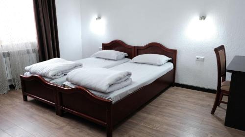 a bedroom with two beds with white pillows at Apple Hostel Bishkek in Bishkek