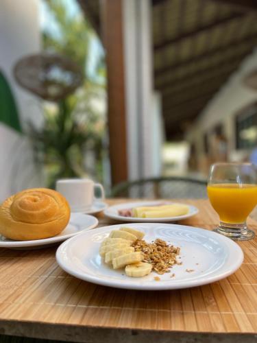 a table with plates of food and a glass of orange juice at Isla Beach Hotel in Pecém