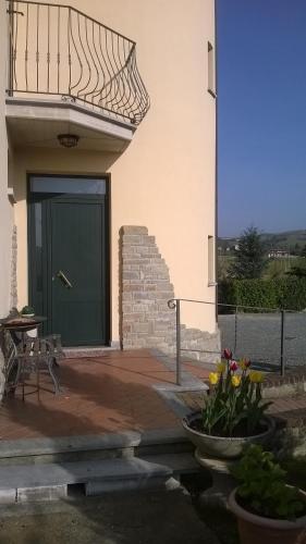 a green door on a building with a table and flowers at Il Girasole in Strevi
