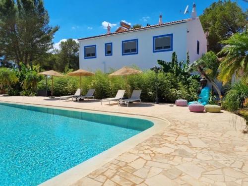 a villa with a swimming pool in front of a house at Superbe villa avec piscine en algarve in Algoz