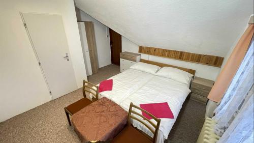 a bedroom with a bed and a table and chairs at Hotel Zlatá vyhlídka in Benecko
