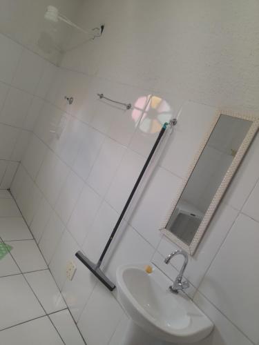 a white bathroom with a sink and a mirror at POUSADA PERLLA's Pindamonhangaba in Pindamonhangaba