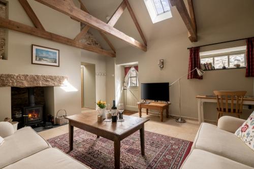 a living room with a table and a fireplace at Lambriggan Court in Perranzabuloe