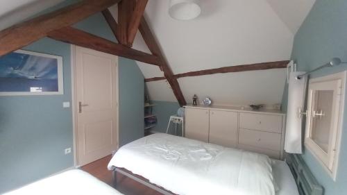 ein Schlafzimmer mit einem weißen Bett und einer blauen Wand in der Unterkunft Gîte des Cardonnières in Carennac