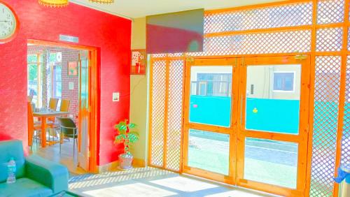 a room with a red wall with a sliding glass door at Hotel River View Resort in Pahalgām