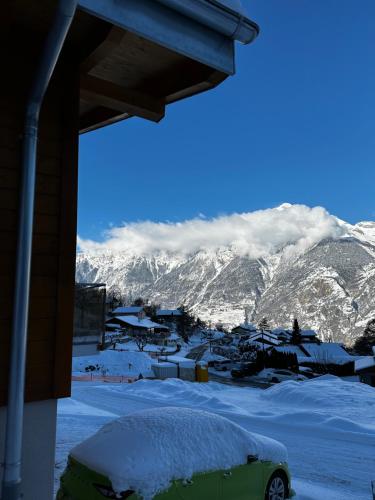 a view of a snow covered mountain from a house at Chalet Les Louettes à Sapinhaut Canton du Valais in Saxon