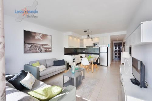 salon i kuchnia z kanapą i stołem w obiekcie Casa Patty, piscinas climatizadas, primera linea w Costa Teguise