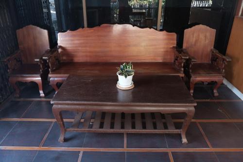 a table with a potted plant sitting on top of it at Manilath guesthouse in Ban Houayxay