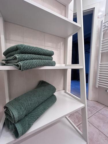 a group of green towels on shelves in a bathroom at Urlaub im Kavaliershaus in Schwerin