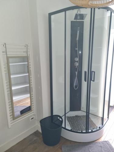 une douche avec une enceinte en verre à côté d'un miroir dans l'établissement Jolie petite maison dans village fortifié, à Brigueuil