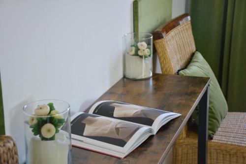 a wooden table with two vases and a book on it at B&B Fashion style in Cagliari