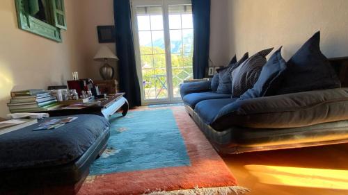 a living room with a blue couch and a window at The Traditional in Ollon