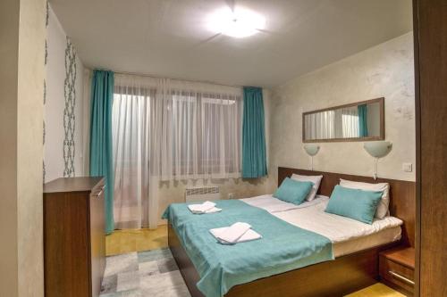 1 dormitorio con 1 cama con 2 toallas en Форест Нук - апартамент, en Pamporovo