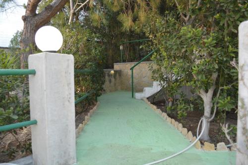 a green walkway with a hose attached to a tree at Hotel Finiki View in Foinikion