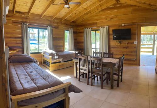 a dining room with a table and chairs in a log cabin at Complejo Anthea in Villa Yacanto