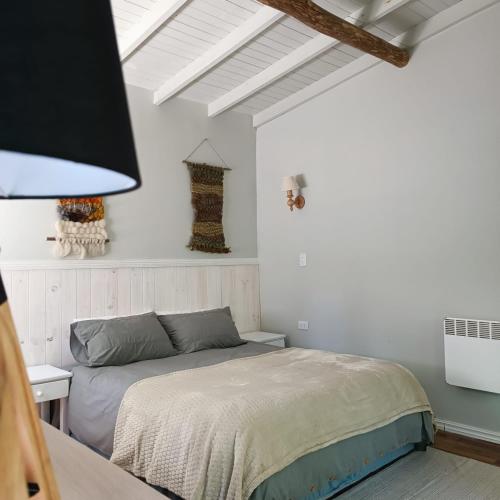 a bedroom with a bed in a white room at Lodge Tenis Pucon cl in Pucón