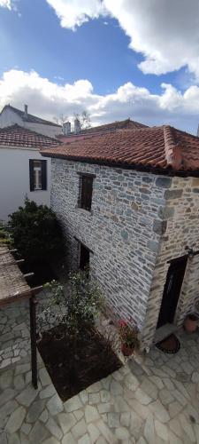 a brick house with a stone patio in front of it at Αρχοντικό Ταξίμι (Μουντζουρίδη) in Argalasti