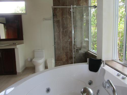 a bathroom with a tub and a shower and a toilet at La Manigua hostal in Buenaventura