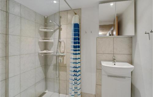 La salle de bains est pourvue d'une douche et d'un lavabo. dans l'établissement Nice Home In Outrup With Kitchen, à Ovtrup