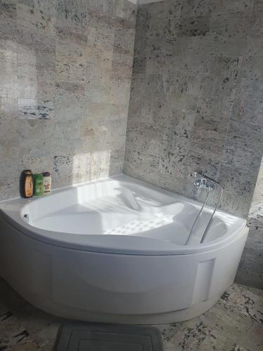 a white tub in a bathroom with a stone wall at Il Castelletto di Gomo in Godiasco