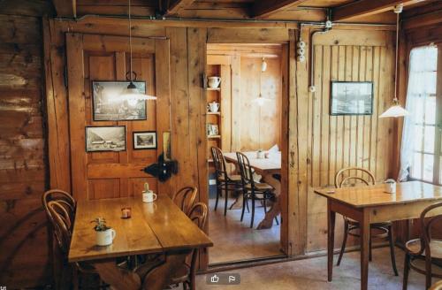 ein Esszimmer mit Holzwänden, Tischen und Stühlen in der Unterkunft Berghotel Gasterntal in Kandersteg